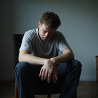 Fáradt, deprimált ember ül egy széken